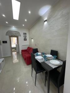 a living room with a table and a red couch at Casa vacanza l’archetto in Genzano di Roma