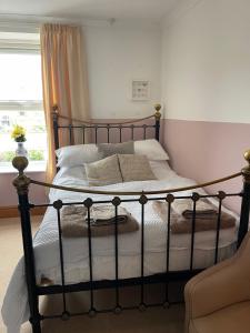 a bedroom with a large bed with a wrought iron frame at Heart of Cockermouth Gem 4 bedrooms 6 beds 2 bathrooms in Cockermouth