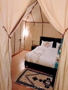 a bedroom with a bed in a tent at Khamlia Desert Luxury Camp in Merzouga