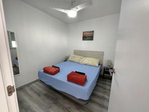 a bedroom with a bed with two red pillows on it at CG4N - Nuevo Estudio, recién reformado, Wifi in Torremolinos