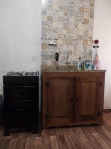 una cucina con piano cottura e bancone con lavandino di Apartamento Bela Vista a Tiradentes