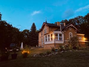 una casa grande con luces en el patio por la noche en FamilyandBike en Neupetershain