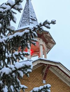un campanario de un edificio con un árbol nevado en FamilyandBike en Neupetershain