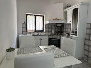 una cocina blanca con armarios blancos y fregadero en Quiet countryside apartments near the city and the sea, en Koper