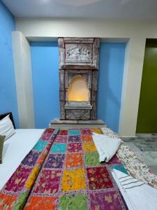 a bed with a colorful quilt on it with a fireplace at Swiss House in Jodhpur