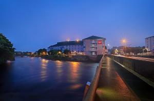 een uitzicht op een rivier in de nacht met een gebouw bij Leonardo Hotel Galway in Galway