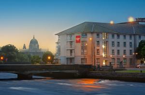 uma ponte sobre um rio em frente a um edifício em Leonardo Hotel Galway em Galway