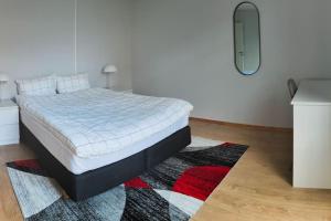 una camera da letto con un letto con un tappeto di Arctic Tromso Apartment 1 a Tromsø