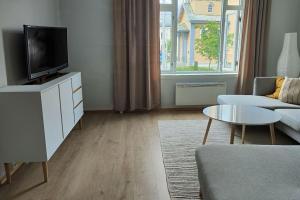 un soggiorno con TV, divano e tavolo di Arctic Tromso Apartment 1 a Tromsø