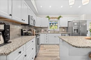 a kitchen with white cabinets and granite counter tops at Heated Pool, Arcade, 2 Kings, 75 Tv, Near Ami-img in Bradenton