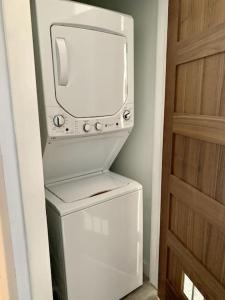 a white refrigerator with a tv on top of it at Collect3 2BR 1BA Close to Train and NYC in Newark