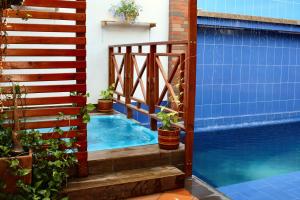 a swimming pool with a wooden stair next to a house at Amano Property in Santa Marta