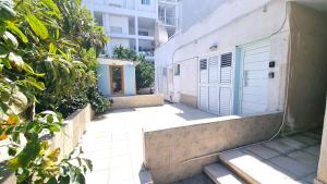 une passerelle avec un bâtiment doté d'une porte bleue dans l'établissement Dream Escape Apt 1 - 6 min walk to Kastella Beach!, à Larnaka