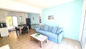 a living room with a blue couch and a table at Dream Escape Apt 1 - 6 min walk to Kastella Beach! in Larnaka