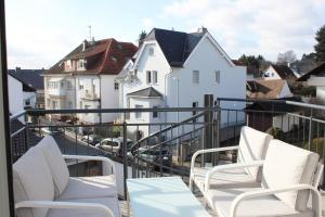a balcony with two chairs and a view of buildings at Beautiful terrace apartment in Bad Soden in Bad Soden am Taunus