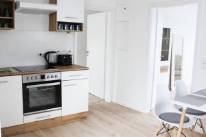 a kitchen with white appliances and a table and chairs at Beautiful terrace apartment in Bad Soden in Bad Soden am Taunus