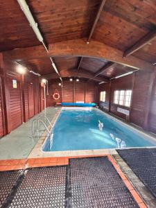 a large swimming pool in a wooden building at Wigbay Loch View 28 in Kirkcolm