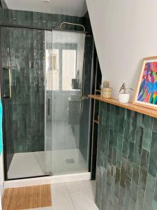 um chuveiro com uma porta de vidro na casa de banho em Appartement au pied de Montmartre / Jules Joffrin em Paris