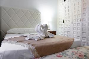 Una cama con dos cisnes envueltos en toallas blancas en Complejo Rural Victory en Cuenca