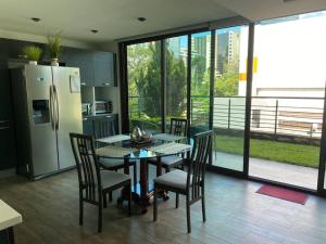 危地马拉Apartamento Edificio Urbana Z.10的配有桌椅和冰箱的厨房