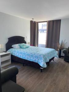 a bedroom with a bed with a blue blanket at Apartamento Edificio Urbana Z.10 in Guatemala +10 photos