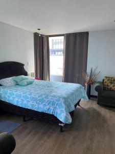 a bedroom with a bed and a window and a chair at Apartamento Edificio Urbana Z.10 in Guatemala