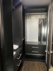 a bathroom with black cabinets and a mirror at Apartamento Edificio Urbana Z.10 in Guatemala