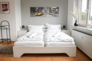 uma cama branca com almofadas num quarto em Remark Studios - Wohnung für 6 in Großburgwedel em Burgwedel