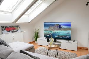 uma sala de estar com uma televisão de ecrã plano no tecto em Remark Studios - Wohnung für 6 in Großburgwedel em Burgwedel