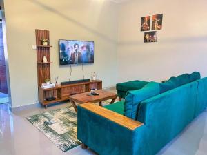 a living room with two blue couches and a tv at Cozy & tranquil 1 Bedroom dainty haven in Kampala in Buwate