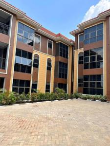 a large building with a brick driveway in front of it at Cozy & tranquil 1 Bedroom dainty haven in Kampala in Buwate