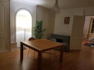 una sala de estar con una mesa y un sofá en La place aux fleurs, en Dole
