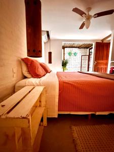 a bedroom with a bed and a table and a fan at Casa da Arquiteta Guest House in Ilhabela