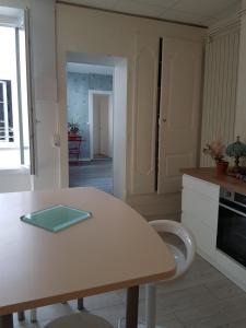 una cocina con una mesa y una encimera en La place aux fleurs, en Dole 2 fotos más