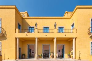 een geel gebouw met een balkon erboven bij Casa Cuseni, Patrimonio Culturale Immateriale UNESCO in Taormina