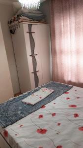 ein Schlafzimmer mit einem Bett mit roten Blumen darauf in der Unterkunft Gardenya rezidans 1+1 in Antalya