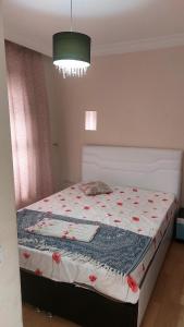 ein Schlafzimmer mit einem Bett mit einer Decke darauf in der Unterkunft Gardenya rezidans 1+1 in Antalya