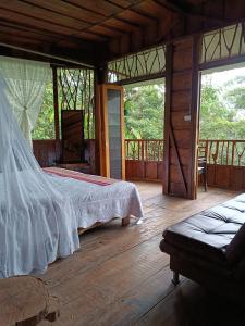 1 dormitorio con 1 cama y suelo de madera en Huaca Huaca Hostel en Mocoa