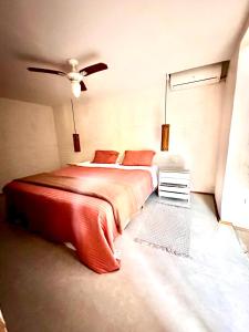 een slaapkamer met een bed en een plafondventilator bij Casa da Arquiteta Guest House in Ilhabela