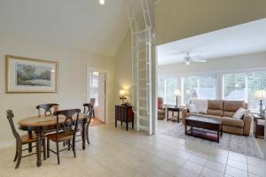 a living room with a spiral staircase and a dining room at Inviting Summer Village Cottage Golf Cart and More! in Westford