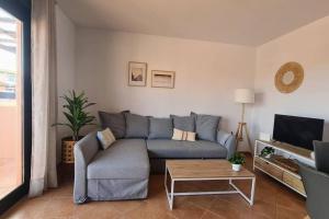 a living room with a blue couch and a coffee table at Vivienda en Lajares " Casa Sua " in La Oliva