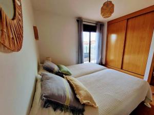 a bedroom with a bed with pillows and a window at Vivienda en Lajares " Casa Sua " in La Oliva +33 photos