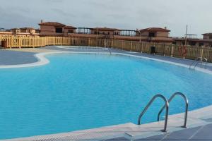 a large swimming pool with blue water at Vivienda en Lajares " Casa Sua " in La Oliva