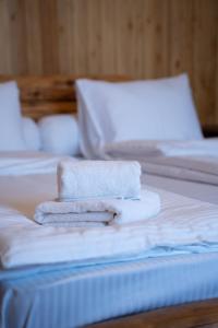 trzy ręczniki są ułożone na górze łóżka w obiekcie Hotel Piano Kvareli w mieście Kvareli