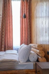 a bedroom with a bed with pillows and a window at Hotel Piano Kvareli in Kvareli