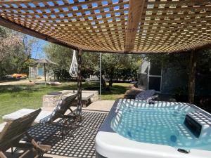 a hot tub sitting under a wooden pergola at Manna Gea Glamping Domes in Vonitsa
