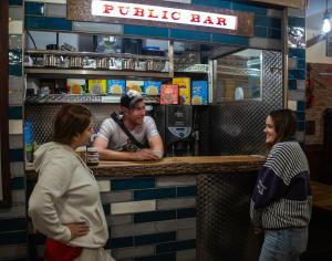 a group of people standing at a public bar at The Liverpool Pod Travel Hostel in Liverpool
