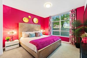 1 dormitorio con paredes rosas y 1 cama grande en Fairfax District Chic City Oasis 2 BR Apt with Den 136, en Los Ángeles