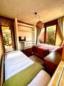 a bedroom with two beds and a window at Casa da Arquiteta Guest House in Ilhabela