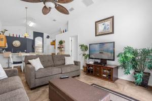 a living room with a couch and a flat screen tv at 201 Hideaway beach 4 beds - pool&spa in Kissimmee